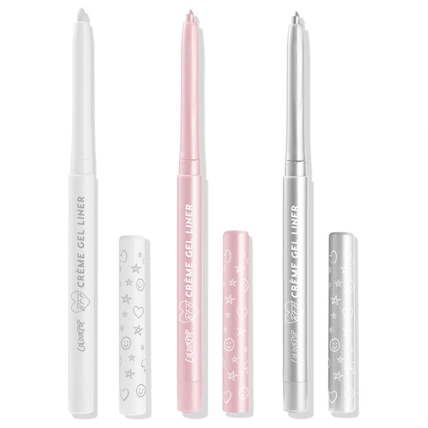 Total Essentials ColourPop Crème Gel Liner trio stands uncapped, displaying retractable tips in white, soft pink, and metallic silver with matching doodle-print caps alongside, studio-lit on a white background.