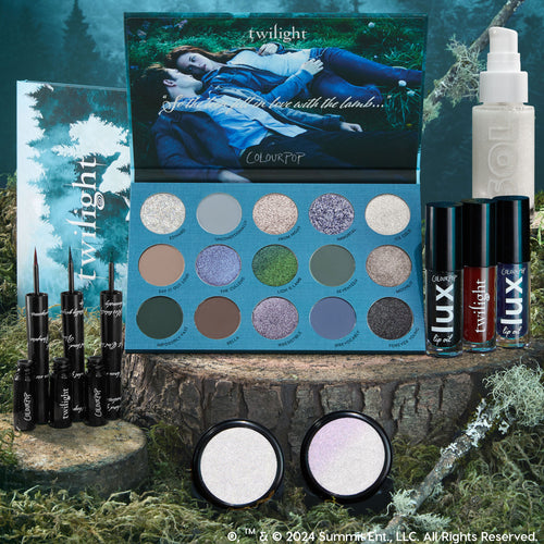 Twilight x ColourPop Full Collection Set displayed on a mossy stump, featuring a 15-pan cool-toned eyeshadow palette, three black liquid liners, three Lux lip oils, two iridescent highlighters, and a SOL shimmer body oil in forest-themed packaging.