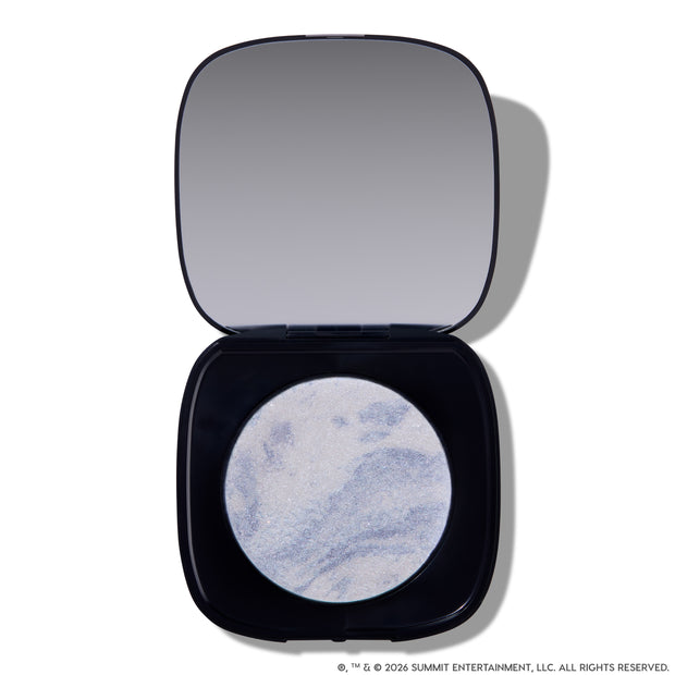 Open compact of Change Me Mega Highlighter with shimmering icy lavender and silver marbled pan set in a sleek black case with mirror, styled on a white background for the Twilight makeup collection.