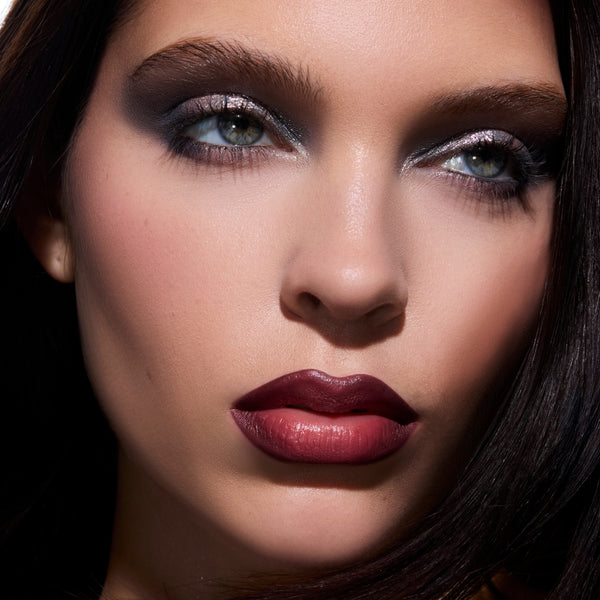 Model wears the The Twilight Saga Eclipse X ColourPop full collection set with smoky silver Twilight-inspired eyeshadow, dramatic dark berry ombré lipstick, and soft blush, shown in a close-up glam beauty shot for US makeup lovers.