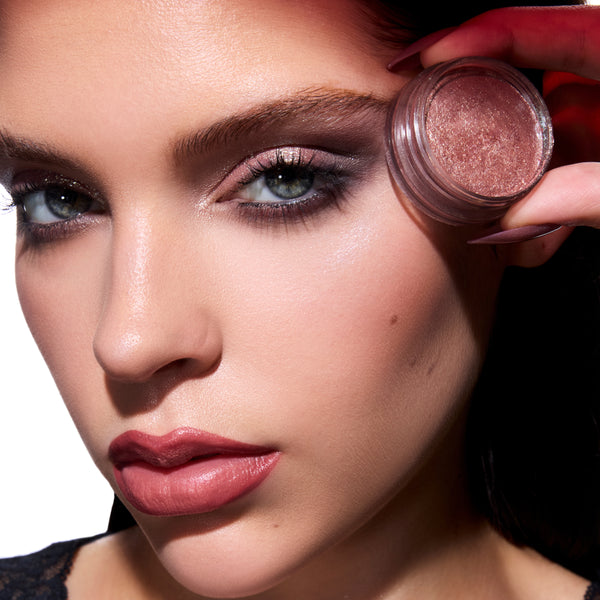 Model holds ColourPop Coven Clash Jelly Much Duo near her temple, showcasing shimmering rose Twilight eyeshadow on lids with smoky detail and matching mauve lips against a clean studio background.