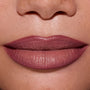 Close-up of full lips wearing ColourPop Opposites Attract Lippie Stix, showing a smooth, satin-matte mauve finish inspired by Twilight tones on medium skin, highlighting even coverage and creamy texture for everyday makeup looks.