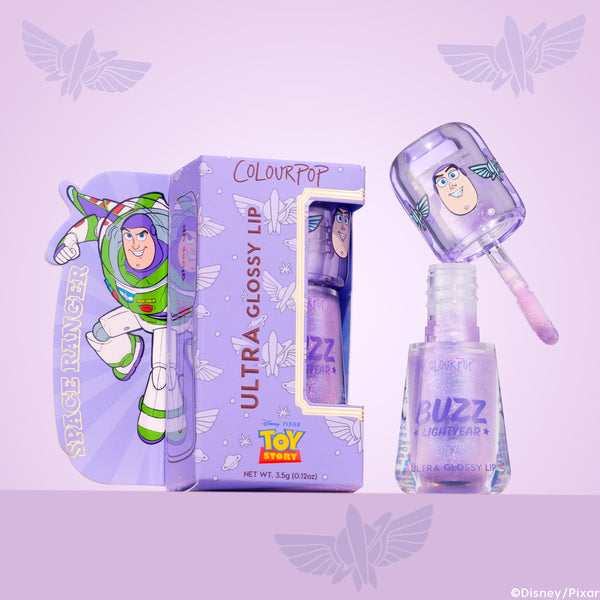 ColourPop Ultra Glossy Lip Buzzin' About, a lavender shimmery gloss, shown open with doe-foot applicator above the bottle, featuring Buzz Lightyear graphics on the cap and box with Disney Pixar Toy Story branding against a purple backdrop.