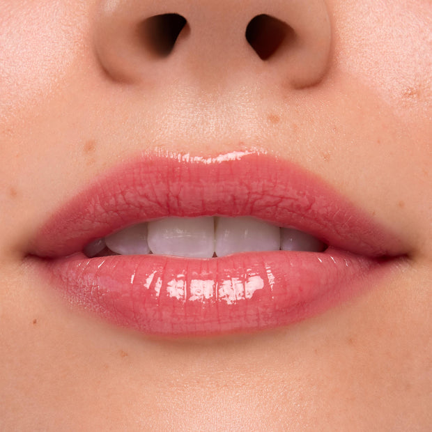 Lips wearing Experiment 626, the ColourPop Ultra Glossy Lip, gleaming with a high-shine sheer rosy pink finish in a tight close-up studio swatch, emphasizing smooth texture and natural lip lines.