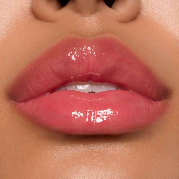Glossy pink lips showcasing ColourPop Ultra Glossy Lip, shade Experiment 626, catching bright studio light with a glassy finish in a tight close-up beauty swatch.