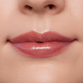 Lips wearing ColourPop Ultra Glossy Lip in Flynn Rider, showing a high-shine sheer rosy nude finish on a close-up model mouth, smooth even coverage and wet-look gloss under studio lighting for a plump, hydrated look.