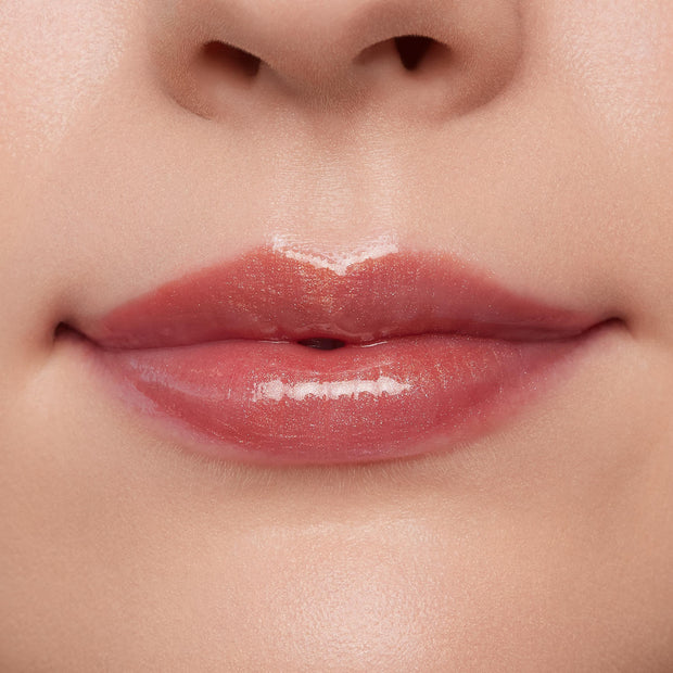 Lips wearing ColourPop Ultra Glossy Lip in Flynn Rider, showing a high-shine sheer rosy nude finish on a close-up model mouth, smooth even coverage and wet-look gloss under studio lighting for a plump, hydrated look.