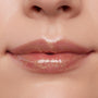 Glossed lips wearing ColourPop Ultra Glossy Lip in Pascal, a sheer clear gloss with gold micro-shimmer, reflecting studio light for a high-shine finish in a close-up beauty swatch.