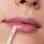 Close-up of a model applying shimmery pink Ultra Glossy Lip from the Disney Tangled and ColourPop Collection full collection set, showing high-shine finish on lips with the Back In Stock ColourPop gloss wand in use.