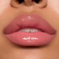Glossy pink lips wearing ColourPop Ultra Glossy Lip in Super Sweet, showcasing a sheer warm pink tint with a glassy, high-shine finish in a studio close-up, highlighting smooth, hydrated texture and precise application.