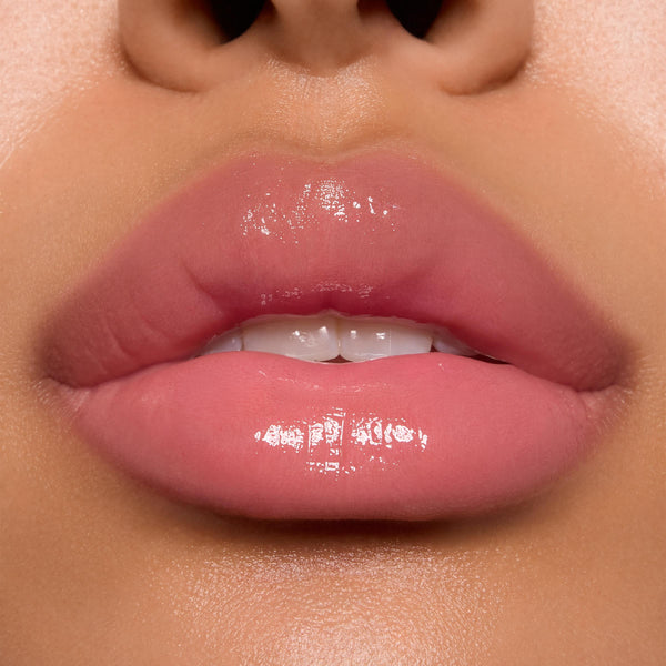 Glossy pink lips wearing ColourPop Ultra Glossy Lip in Super Sweet, showcasing a sheer warm pink tint with a glassy, high-shine finish in a studio close-up, highlighting smooth, hydrated texture and precise application.