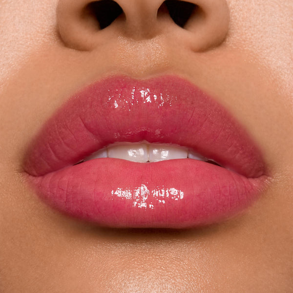 Glossy lips wearing ColourPop Ultra Glossy Lip in Surfer Vibes, delivering a sheer rosy pink tint with a high-shine, glassy finish in a tight studio close-up that highlights even coverage and reflective shine.