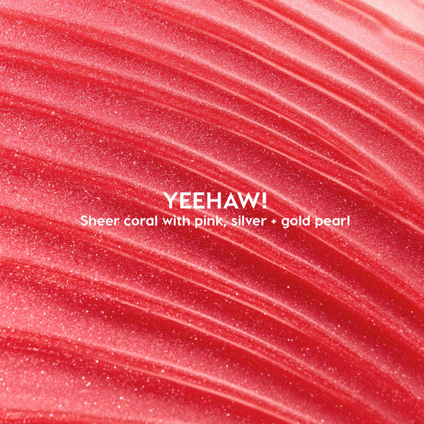 Macro swatch of Yeehaw ColourPop Ultra Glossy Lip - sheer coral gloss with pink, silver, and gold pearl - swept in luminous ridges to showcase its high-shine, smooth texture.
