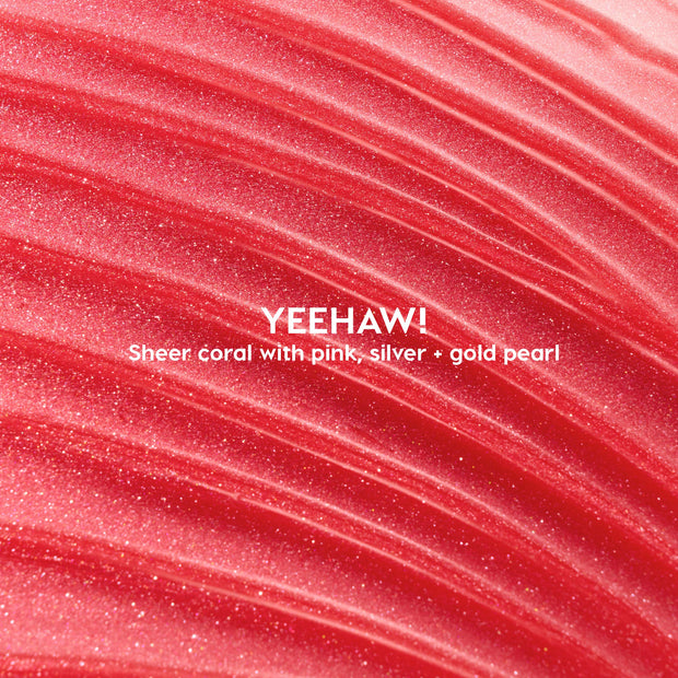 Macro swatch of Yeehaw ColourPop Ultra Glossy Lip - sheer coral gloss with pink, silver, and gold pearl - swept in luminous ridges to showcase its high-shine, smooth texture.