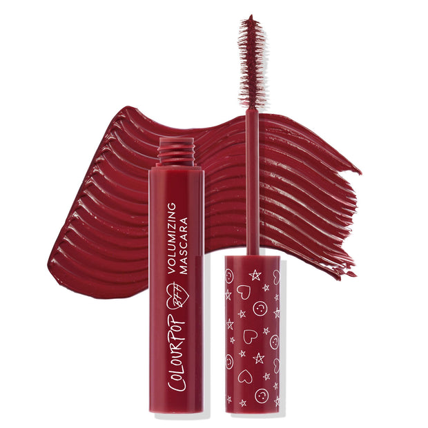 ColourPop BFF Mascara wand in Wine O'Clock brushing on rich burgundy pigment, shown with the open volumizing tube and patterned cap, set against a matching wine-red swipe to showcase color payoff and texture.