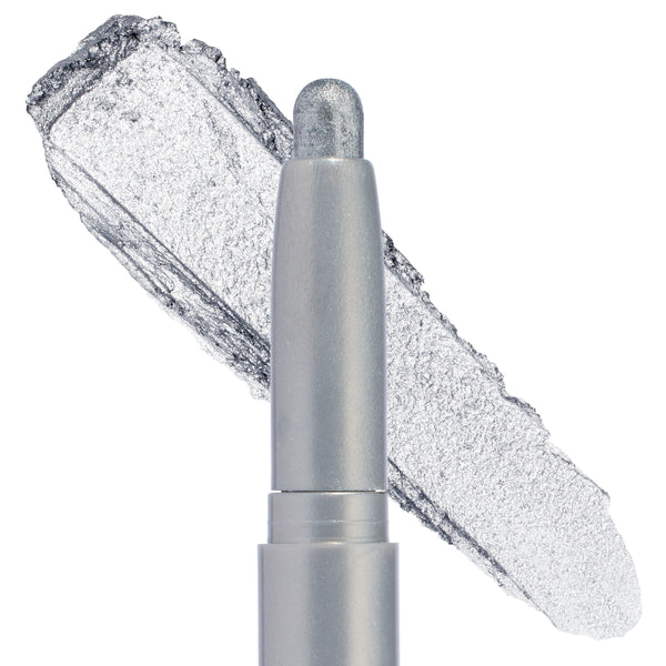ColourPop Shadow Stix in Witch, Please gliding a cool‑toned silver metallic swatch, shown in a macro close‑up on a white background, featuring a rounded twist‑up cream eyeshadow tip with high‑shine foil shimmer.
