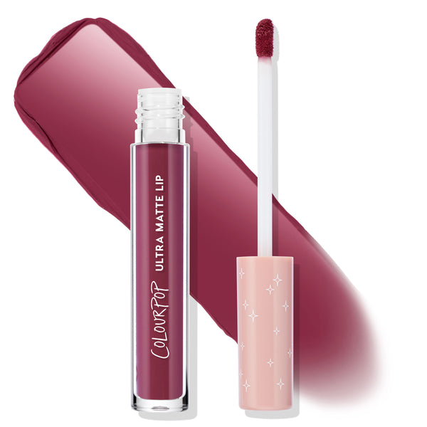 ColourPop Ultra Matte Lip in You Win swatched; deep berry-plum liquid lipstick in a clear tube with white logo and doe-foot applicator, peach cap with star print, set against a bold matte wine swipe showcasing color payoff.