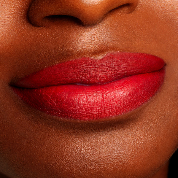 Bossy ColourPop Lippie Pencil outlining and filling lips in a bold true red, showing sharp definition and a smooth matte finish in an extreme close-up beauty shot.