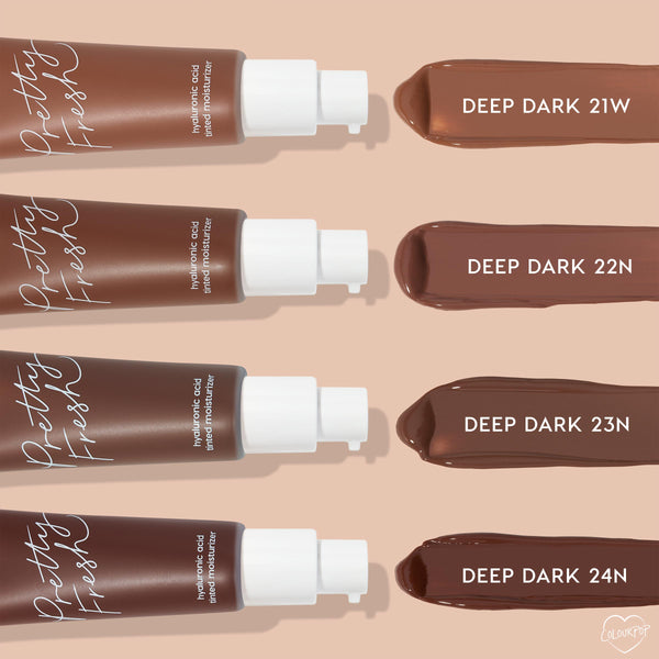 ColourPop Pretty Fresh Tinted Moisturizer in Deep Dark 23 N - third swatch in a row - shown alongside deep shades 21W, 22N, and 24N next to four pump bottles, highlighting the hyaluronic acid formula on a beige background.