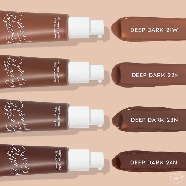 ColourPop Pretty Fresh Tinted Moisturizer in Deep Dark 23 N - third swatch in a row - shown alongside deep shades 21W, 22N, and 24N next to four pump bottles, highlighting the hyaluronic acid formula on a beige background.