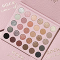 Rock Candy ColourPop Shadow Palette opens to a 30-pan 6x5 grid, showcasing matte, shimmer, and glitter neutrals and pinks - ivory, champagne, rose, taupe, copper, silver, charcoal, and black - set on blush-pink, gold-foil Rock Candy packaging.