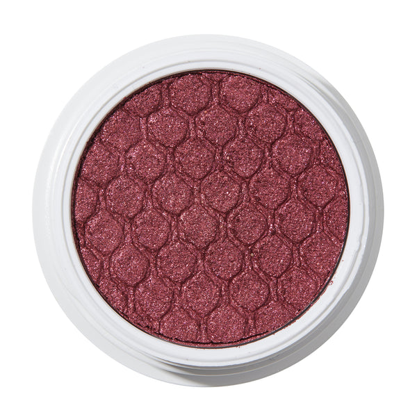 ColourPop Drift Super Shock Shadow displays a metallic cranberry-burgundy shimmer, pressed with a quilted scale pattern, sitting in a round white pot on a plain white studio background.