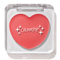Heart-shaped ColourPop Lip and Cheek Balm in It’s a Look resting in a clear square compact with lid closed, showcasing a warm coral-pink shade and white ColourPop logo on a clean white background.
