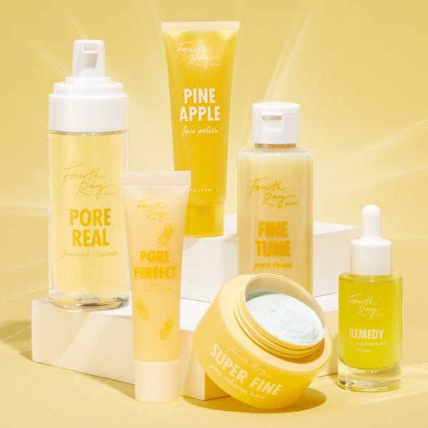 Pore Real Cleanser foaming face cleanser by ColourPop Fourth Ray Beauty stands center-left with a white pump, displayed beside Pineapple Face Polish, Fine Tune pore tonic, Super Fine mask, and Remedy serum on a bright yellow studio backdrop.