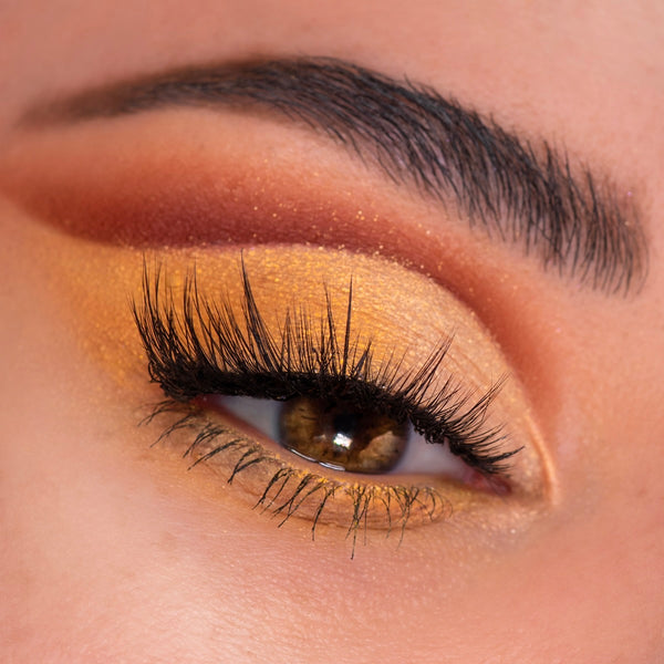 Warm honey-gold shimmer lids with a burnt orange crease and long lashes showcase the Sweet As Can Bee ColourPop Shadow Palette, a shadow palette, in a close-up of a brown eye with defined brow, highlighting rich pigment and metallic finish.