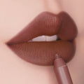 ColourPop Lippie Pencil in CTRL lines full lips, the creamy nude-brown shade gliding along the lower lip to define a matte pout; close-up highlights the precise tip and smooth, full-coverage finish.