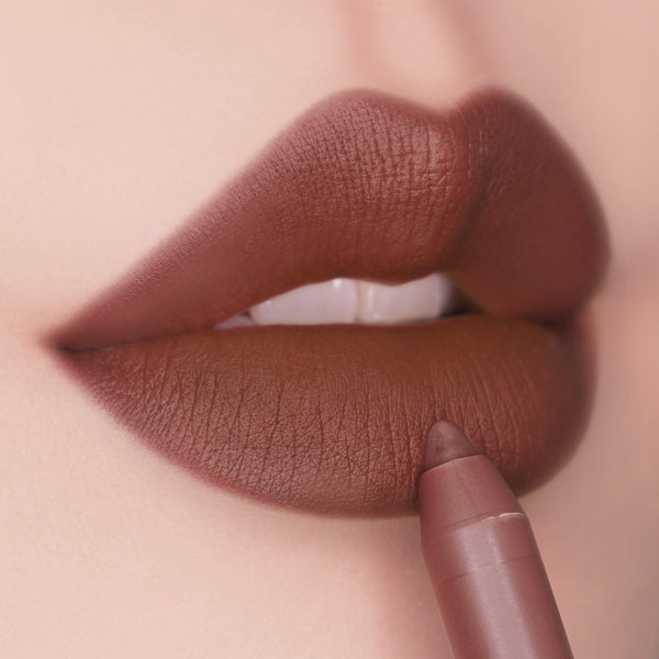 ColourPop Lippie Pencil in CTRL lines full lips, the creamy nude-brown shade gliding along the lower lip to define a matte pout; close-up highlights the precise tip and smooth, full-coverage finish.