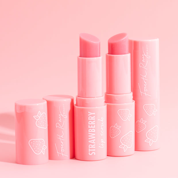 Strawberry lip balm sticks stand uncapped, revealing rosy bullets, in glossy pink Fourth Ray Beauty tubes with white strawberry icons on a soft pink backdrop - Strawberry flavor ColourPop Lip Balm for soft, hydrated lips.