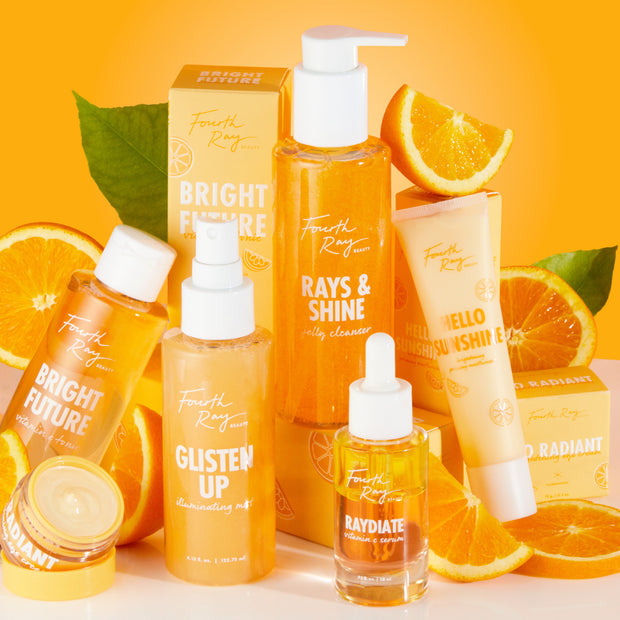 RAYdiate Vitamin C Serum dropper bottle stands front-center, showcasing golden liquid as the featured ColourPop Face Serum, surrounded by Fourth Ray citrus skincare, orange slices, and boxes on a bright orange backdrop.