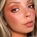Rock On ColourPop Shadow Palette creating a copper shimmer eye on a model, blending warm terracotta in the crease with a bright inner-corner highlight, paired with long lashes, peach blush, and glossy nude lips in a studio close-up.