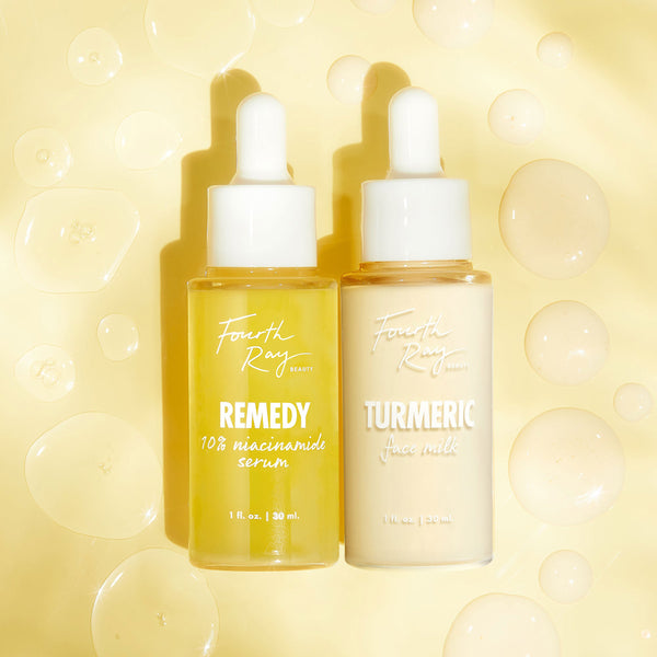 Two Fourth Ray Beauty bottles - Remedy 10% Niacinamide Serum and Turmeric Face Milk, 1 fl oz each - stand side by side with droppers, showcasing the Revive Skin Boost Duo by ColourPop Skin Boost Duo on a pale yellow backdrop with glossy serum drops.