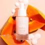 Fourth Ray Beauty Papaya Face Milk bottle standing upright with white dropper, labeled 0.95 fl oz/28 ml, surrounded by bright orange papaya wedges, seeds, and milky drops on a peach backdrop, highlighting this hydrating ColourPop Face Milk.