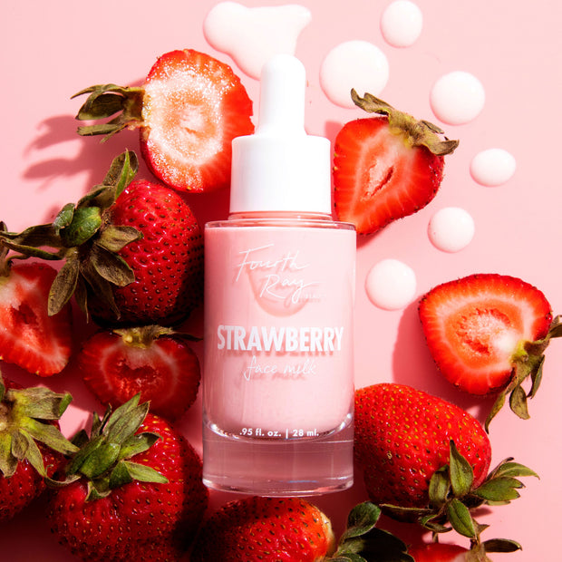 Pink glass dropper bottle of Fourth Ray Beauty Strawberry Face Milk (0.95 fl oz/28 ml) standing amid sliced strawberries and milky droplets on a blush backdrop, highlighting a hydrating ColourPop Face Milk serum.