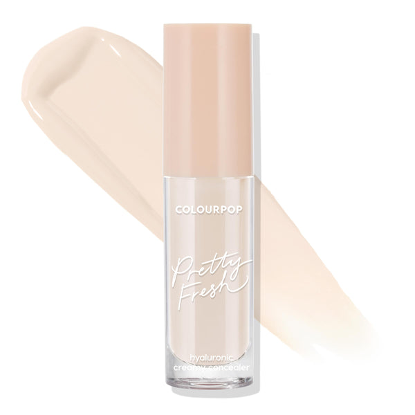 ColourPop Pretty Fresh Creamy Concealer in Fair 15 W stands upright with a blush pink cap, showcasing a large light‑warm beige swatch behind it to highlight the shade and creamy coverage on a clean white background.