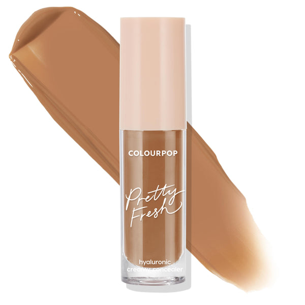 ColourPop Pretty Fresh Creamy Concealer in Dark 175 N stands upright, displaying a clear tube with blush cap and hyaluronic formula as a rich neutral-brown swatch sweeps behind on a white background, showcasing the shade and coverage.