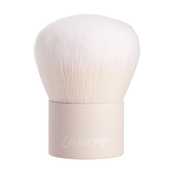 Kabuki Face & Body Brush showcasing dense, dome-shaped white bristles fanning from a short matte nude handle with ColourPop logo, upright on a white background, a ColourPop Makeup Brush for buffing and blending face and body powders.
