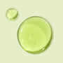Avocado + Aloe Double Shot face serum forming glossy, translucent green drops that pool on a pale mint background, highlighting a lightweight, hydrating texture; ColourPop Face Serum.