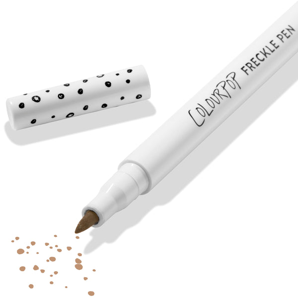 ColourPop Freckle Pen in Soft Brown uncapped, felt-tip applying scattered soft brown freckle dots, with polka-dot white cap beside it on a clean white background; long-wearing, buildable faux freckles makeup.