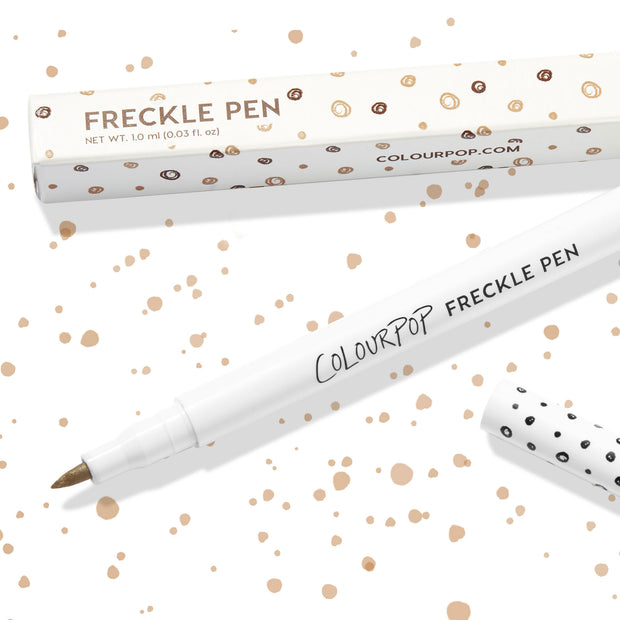 Soft Brown ColourPop Freckle Pen uncapped, felt-tip applicator ready to dot natural-looking freckles, shown with polka-dot cap and matching box on a white background speckled with brown spots; 1.0 ml makeup pen for faux freckles.
