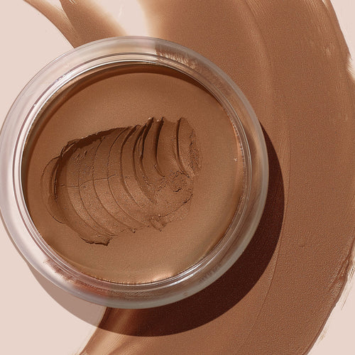 Open jar of ColourPop SOL Face & Body Bronzing Balm, shade Deep, revealing a creamy warm bronze formula with a swirled scoop, set against a broad matching swatch to showcase texture and payoff.