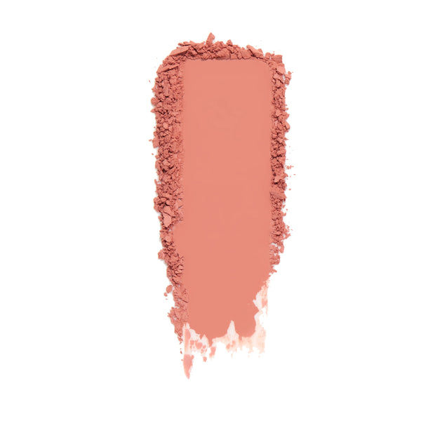 ColourPop Kiss 'N Tell pressed powder blush swatched in a wide matte coral-peach streak with softly crumbled edges, showing smooth, buildable pigment on a clean white background.