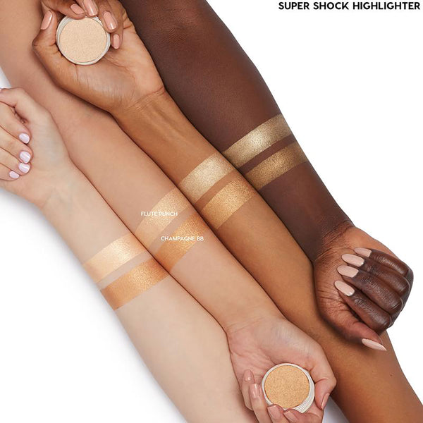 Flute Punch ColourPop Super Shock Highlighter swatched on light, medium, and deep arms, showing a luminous champagne‑gold glow; paired with a Champagne BB comparison stripe, with product pots held in a clean studio shot.