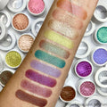 Rose Garden ColourPop Super Shock Shadow swatched on a forearm, a pastel lavender duochrome shimmer labeled “ROSE GARDEN,” shown among teal, gold, and pink swatches; white ColourPop Super Shock Shadow pots surround the arm for shade comparison.