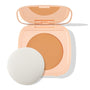 ColourPop Pretty Fresh Face Powder in Medium 12 sits open, revealing a medium-tan pressed powder pan and mirror in a peach compact, with a white round applicator sponge beside it on a clean white background.