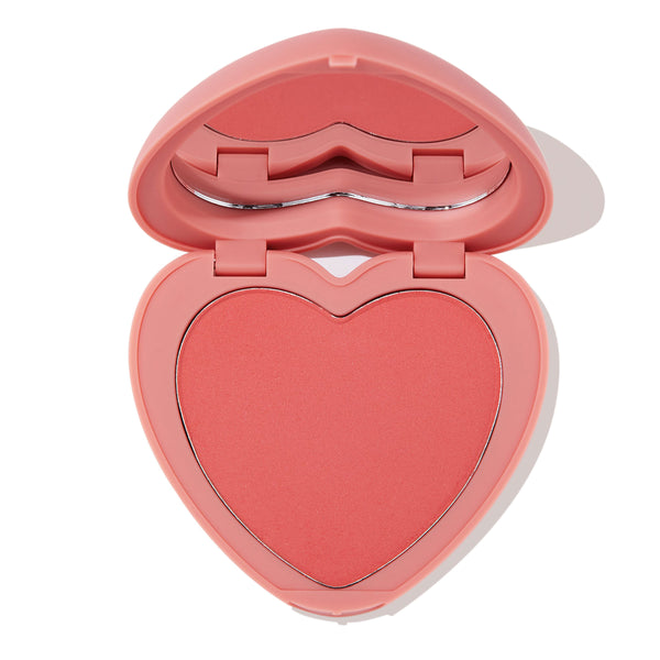 Heart-shaped pink compact sits open to reveal Let’s Dance ColourPop Pressed Powder Blush, a soft coral pan with inner mirror, presented on a clean white background.
