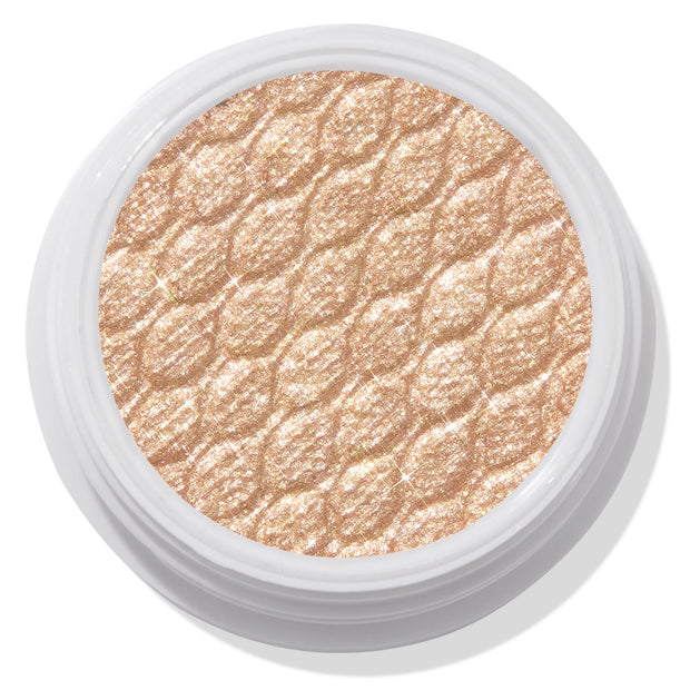ColourPop Super Shock Shadow Flower Child displaying a shimmery champagne-gold eyeshadow pan with a quilted sparkle texture, set in a white round pot on a light backdrop.